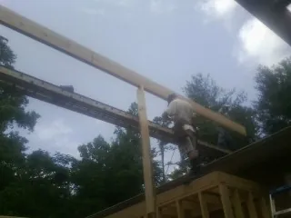 Carpenter setting a ridge beam over a new addition frame — Ice Dam Removal by Roofing Brothers in Eagle